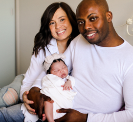 young multicultural family holding newborn baby