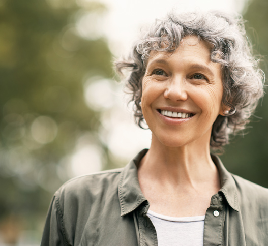 woman smiling with grey hair wearing a shirt